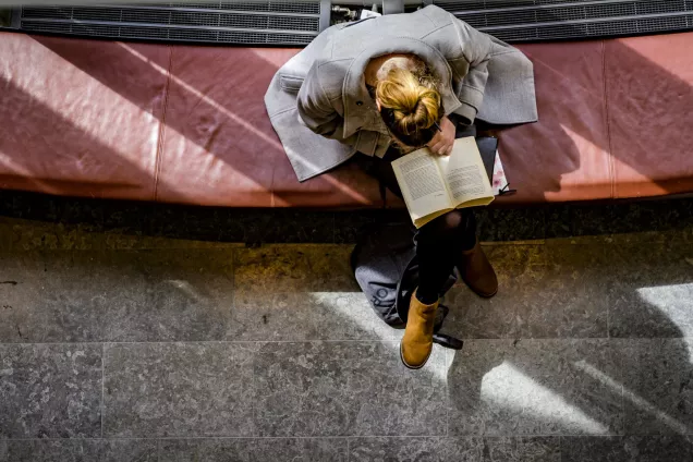 Student reading a book in LUX building