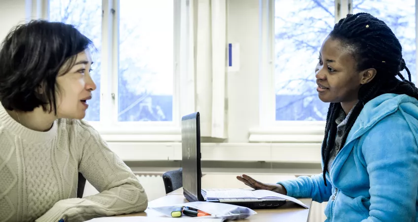 Two students having a discussion during a seminar.